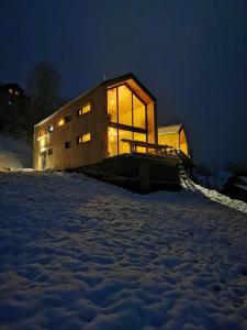 a house in the snow at night with lights on at Cabana Berg in Someşu Rece
