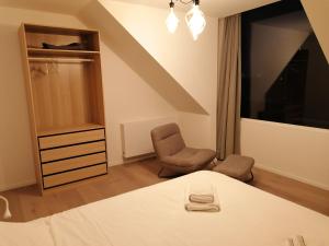 1 dormitorio con 1 cama y 1 silla en appartement deluxe Orly 2, en Ostende