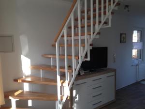 a staircase in a room with a desk and a television at Ferienhaus Brücke in Quedlinburg