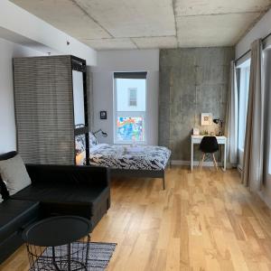 a bedroom with a bed and a couch at Le Studio Cohen "parking inclus" in Quebec City