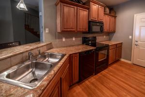 a kitchen with wooden cabinets and a stainless steel sink at Thousand Hills Golf Resort in Branson