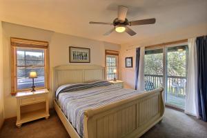 a bedroom with a bed with a ceiling fan and windows at Knock Out #3-MC in Avon