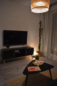 ein Wohnzimmer mit einem TV und einem Couchtisch in der Unterkunft Apartament M&I in Koszalin