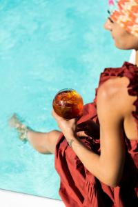 a woman holding a donut in front of a pool at Residenza San Vito in Calamandrana