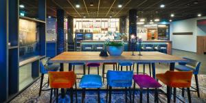 Emils Hotel في بيرماسونس: طاولة مع كراسي ملونة في المطعم