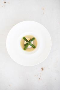 a white plate with a green object in a bowl at Residenza San Vito in Calamandrana