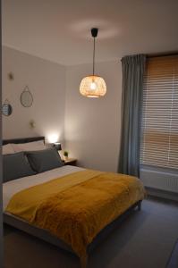 a bedroom with a bed and a pendant light at Apartament M&I in Koszalin