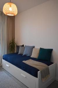 ein Schlafzimmer mit einem großen Bett mit blauer Bettwäsche in der Unterkunft Apartament M&I in Koszalin