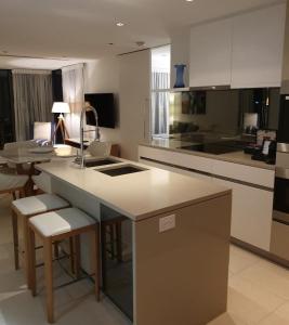 a kitchen with a sink and a counter with stools at High-End Apartment in the Soul of Surfers Paradise in Gold Coast