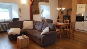a living room with a brown couch and a table at An der Stadtmauer in Korbach