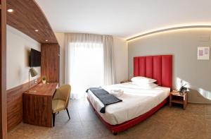 a hotel room with a large bed and a desk at Albergo Giuan Arma di Taggia in Arma di Taggia