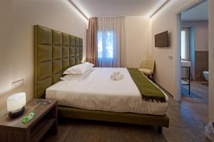 a bedroom with a large bed and a table at Albergo Giuan Arma di Taggia in Arma di Taggia