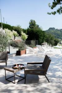 eine Terrasse mit 2 Stühlen und einem Couchtisch in der Unterkunft Residenza San Vito in Calamandrana
