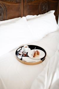 a tray with a plate of food on a bed at Residenza San Vito in Calamandrana