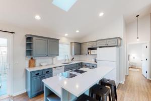 a kitchen with blue cabinets and a white refrigerator at The Surfbird in Pacific City