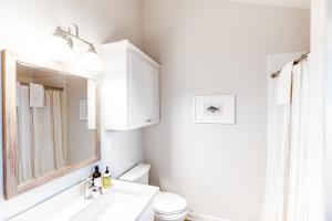 a bathroom with a sink and a toilet and a mirror at The Surfbird in Pacific City +29 photos