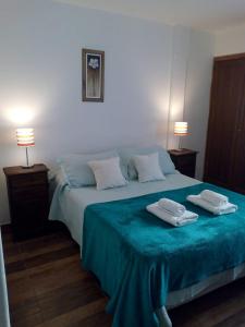 1 dormitorio con 1 cama con 2 toallas en Astoria Patagonia habitaciones privadas en San Carlos de Bariloche