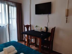 a room with a table and a television on the wall at Astoria Patagonia habitaciones privadas in San Carlos de Bariloche