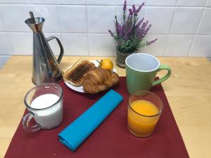 uma mesa com pequeno-almoço de pão de leite e sumo de laranja em El Capricho de Bego em Biescas
