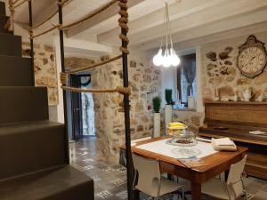 佩特拉利亞索普拉納的住宿－La casetta di Sofi，一间设有桌子和墙上时钟的餐厅