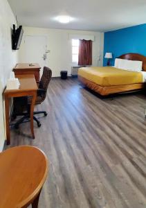 a hotel room with a bed and a desk and a desk at WILLIAMSTON INN in Williamston