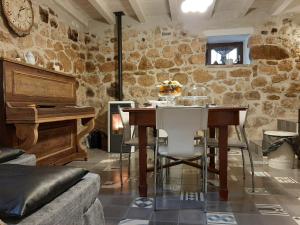 a dining room with a table and a piano at La casetta di Sofi in Petralia Soprana