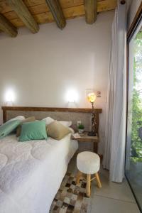 1 dormitorio con cama, mesa y taburete en Hotel Chácara das Flores en São Gabriel