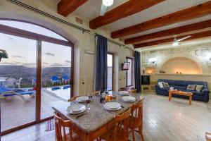 sala de estar con mesa con sillas y sofá en Ta Danjela 4 bedroom Villa with private pool en Xagħra