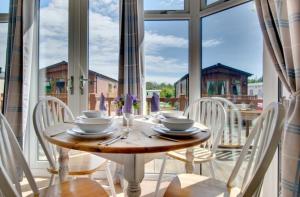 a table and chairs in a room with a large window at Stunning 3-Bed Hot Tub Lodge Northumberland in Felton