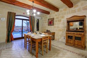 une salle à manger avec une table et une cuisine dans l'établissement Villa Savona 3 Bedroom Villa with private pool, à Ix-Xagħra