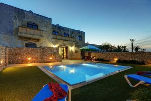 une villa avec une piscine en face d'un bâtiment dans l'établissement Villa Savona 3 Bedroom Villa with private pool, à Ix-Xagħra