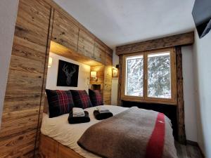 a bedroom with a bed in a room with a window at Verbier Medran + Private Sauna in Verbier