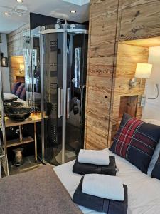 a bedroom with a bed and a glass shower at Verbier Medran + Private Sauna in Verbier