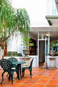 a patio with a table and chairs and a plant at Garlands Del Rio in Puerto Vallarta