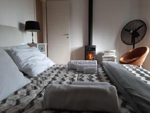 a bedroom with a bed with a fireplace and a chair at La casetta di Sofi in Petralia Soprana
