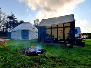 哈佛威斯特的住宿－Mill Haven Place glamping-yurt 2，草地上的一个有火的帐篷