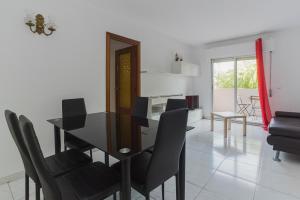 a dining room with a black table and chairs at Apartamentos Complutum in Alcalá de Henares
