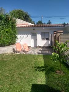 zwei Stühle im Hof eines Hauses in der Unterkunft El Tatu in La Bolsa