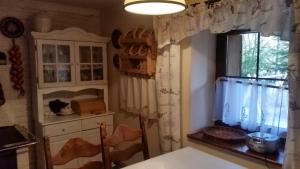kuchnia ze stołem oraz okno z zasłonami w obiekcie Chata Andreasa w Stroniu Śląskim