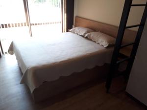 um quarto com uma cama branca e uma escada em MONOAMBIENTE em San Martín de los Andes