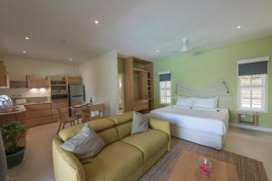 1 dormitorio con sofá, 1 cama y cocina en Residence Praslinoise en Grand'Anse Praslin