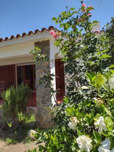 a house with a stone pillar and flowers in front of it at Villa Coca -Los Jilgueros- in La Bolsa