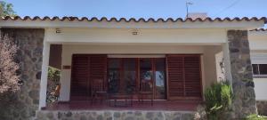una piccola casa con patio arredato con tavoli e sedie di Villa Coca -Los Jilgueros- a La Bolsa