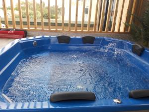 Una piscina azul con cuatro sillas. en Del Valle House, en Ica