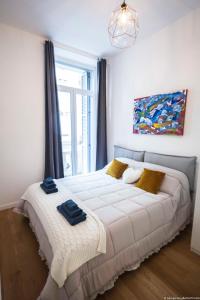a bedroom with a large white bed and a window at Toffee Mombello - Seven Suites Sanremo in Sanremo
