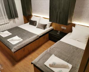 two beds in a small room with white towels at Apartmani Zimski Ples Jahorina in Jahorina