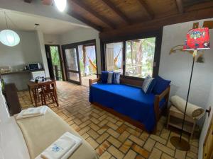 uma sala de estar com uma cama azul e uma mesa em Pousada Villa São Pedro em Garopaba