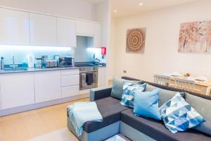 a living room with a couch and a kitchen at Absolute Stays on Grosvenor - St Albans-High Street- Near Luton Airport - St Albans Abbey Train station -Close to London- Harry Potter World - The Odyssey Cinema-Contractors -London Road-Business-Leisure in Saint Albans