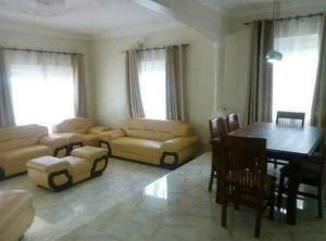 a living room with a couch and a table and a dining room at Go around Kampala all day to return to your wonderful apartment in Kampala