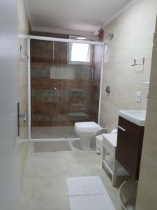 y baño con ducha, aseo y lavamanos. en Apartamento Beira Mar, en Balneário Camboriú